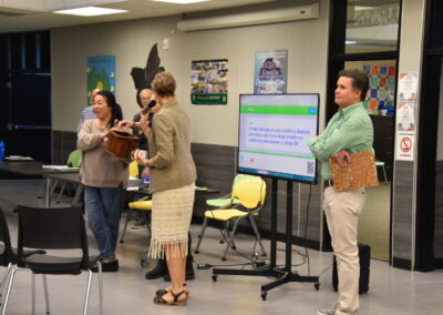 GPC Secretary Benny Allen stands by the Spanish Translation Screen as Principal Jessica Glentzer draws for a door prize.